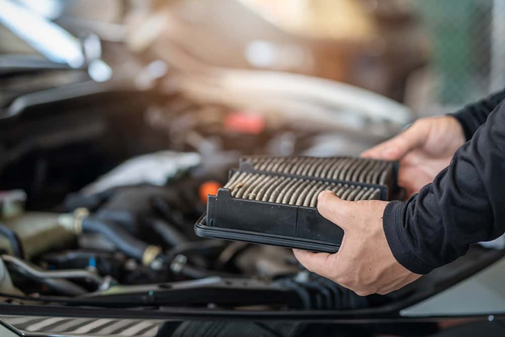Mechanic demonstrating how often to change the engine air filter