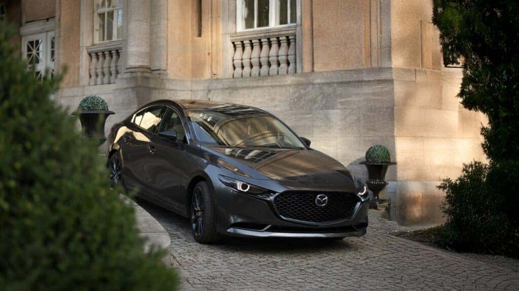 The 2026 Mazda3 Sedan going down an incline in the city