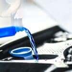 Windshield washer fluid being poured into car