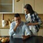 Worried couple looking at bill in kitchen