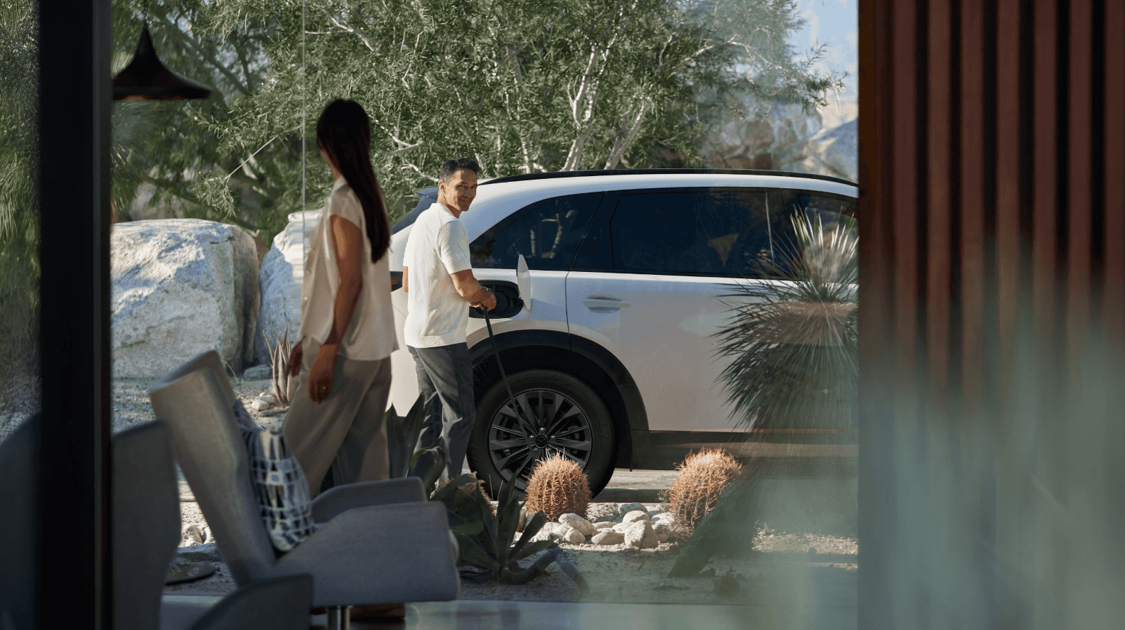 The 2026 Mazda-CX-70 PHEV being charged by a man