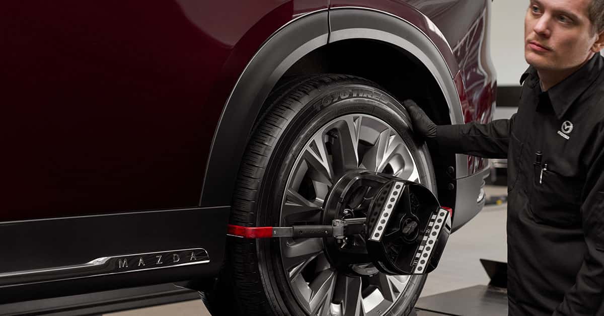 Mazda service technician performing wheel balancing