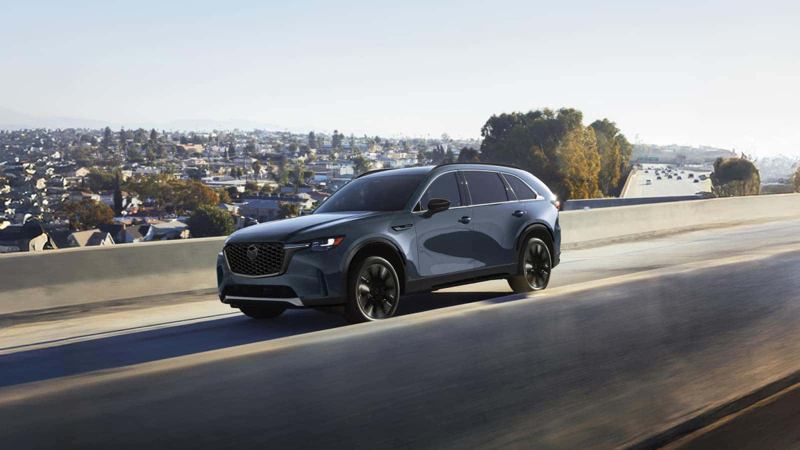 Black 2026 Mazda CX-90 driving down highway