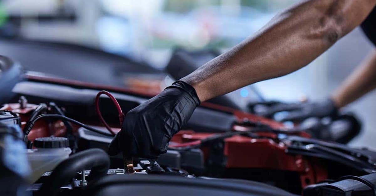 Mazda tech testing battery in engine bay