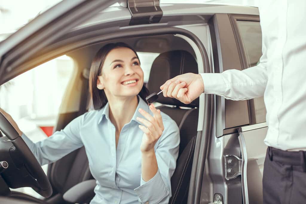 Woman receiving car keys thanks to Volkswagen financing
