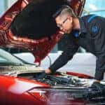 VW technician looking under the hood