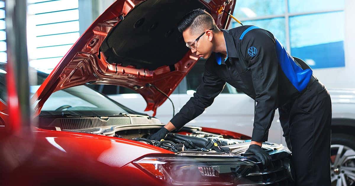 VW technician looking under the hood