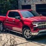 A red 2024 Chevy Silverado 1500 LTZ Z71 parked on a driveway after leaving a Chevy dealer.