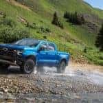 A blue 2024 Chevy Silverado ZR2 driving to a Chevy dealer.
