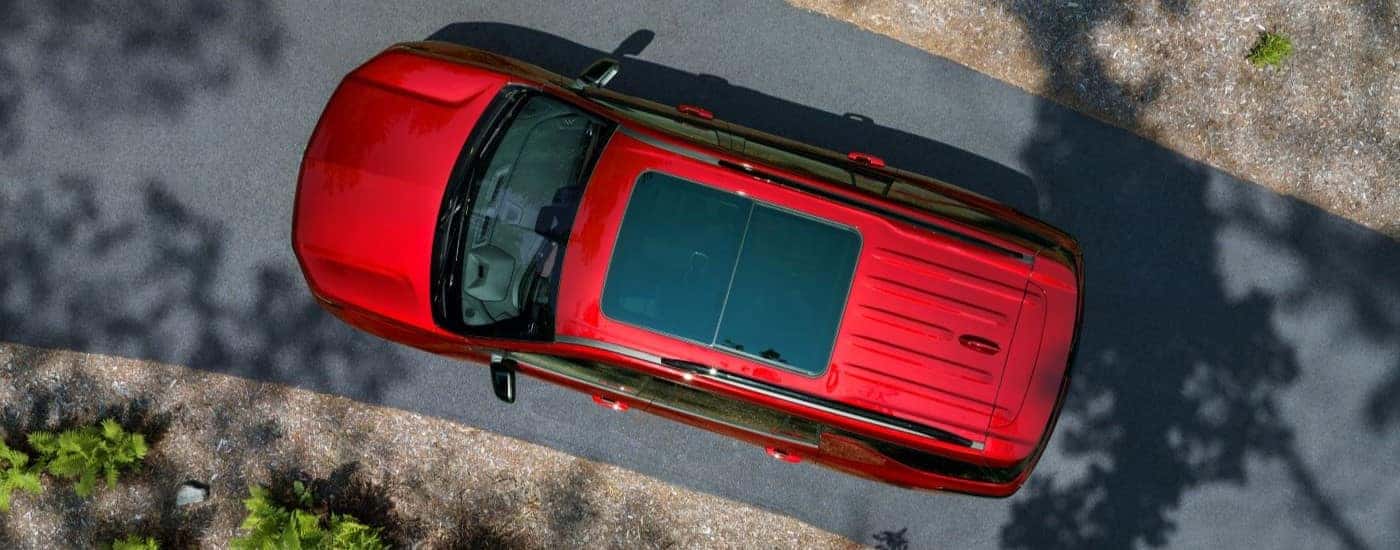 A red 2024 Chevy Traverse leaving a Chevy dealer near Five Forks.