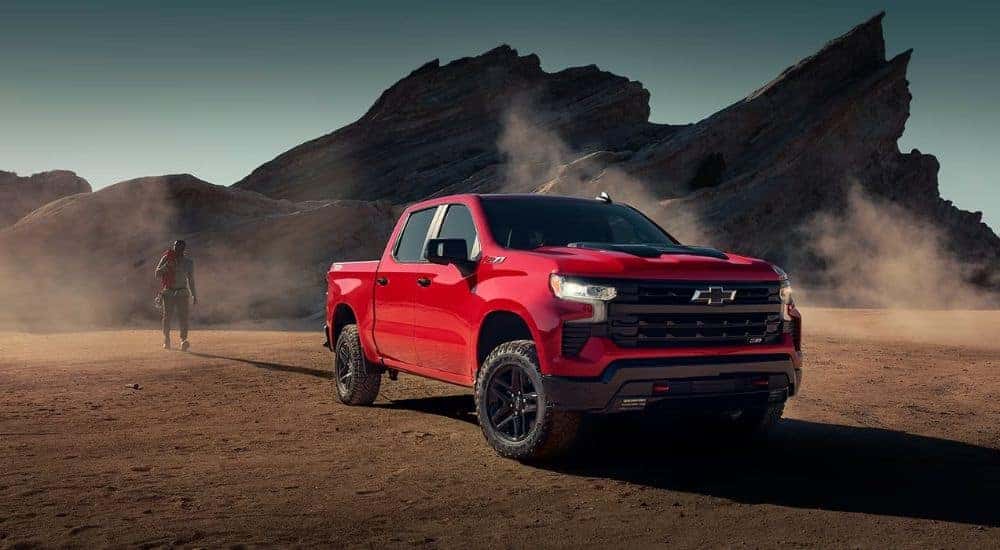 A red 2024 Chevy Silverado 1500 for sale parked on dirt.