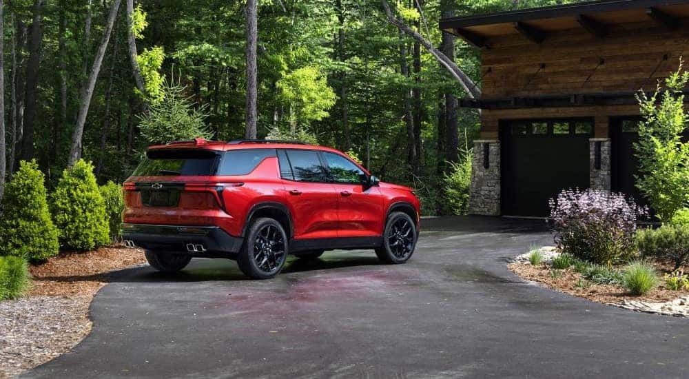 A red 2024 Chevy Traverse RS on a driveway after leaving a Chevy dealer near Five Forks.