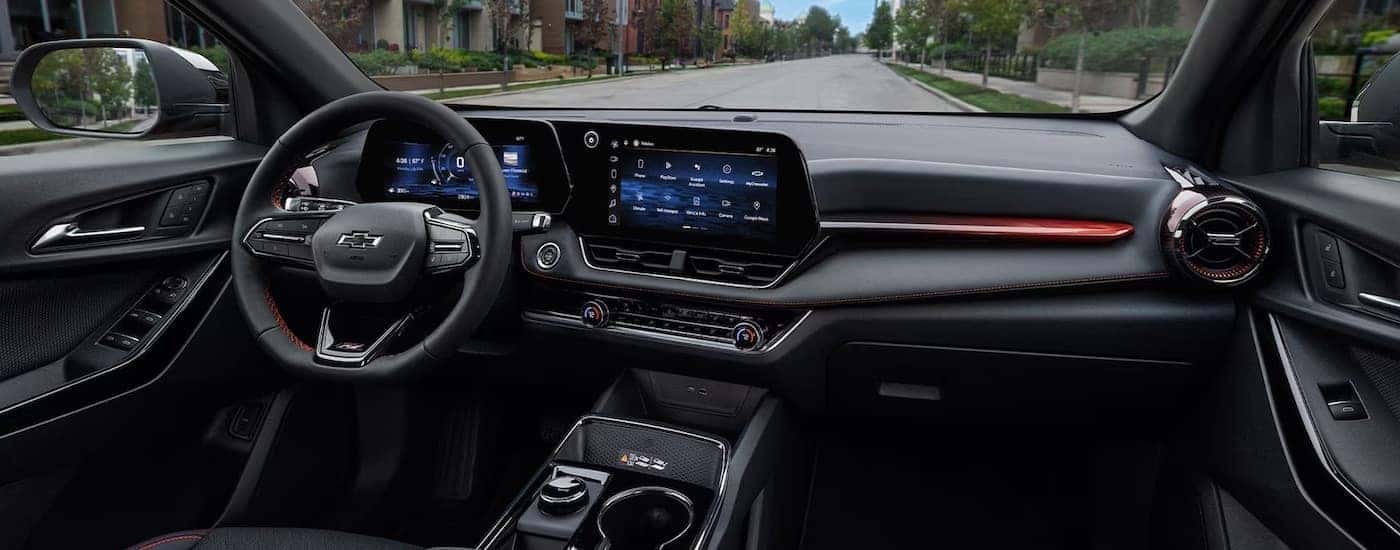 The black interior, steering wheel and dashboard of a 2025 Chevy Equinox.