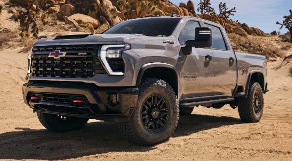 A grey 2024 Chevy Silverado 2500 HD ZR2 parked on dirt.