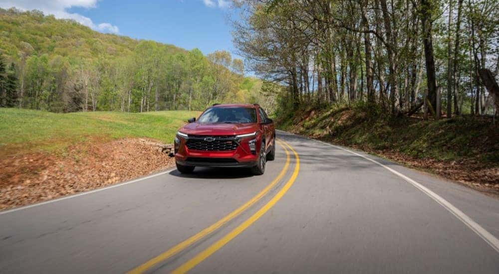 A red 2024 Chevy Trax RS driving down a road.