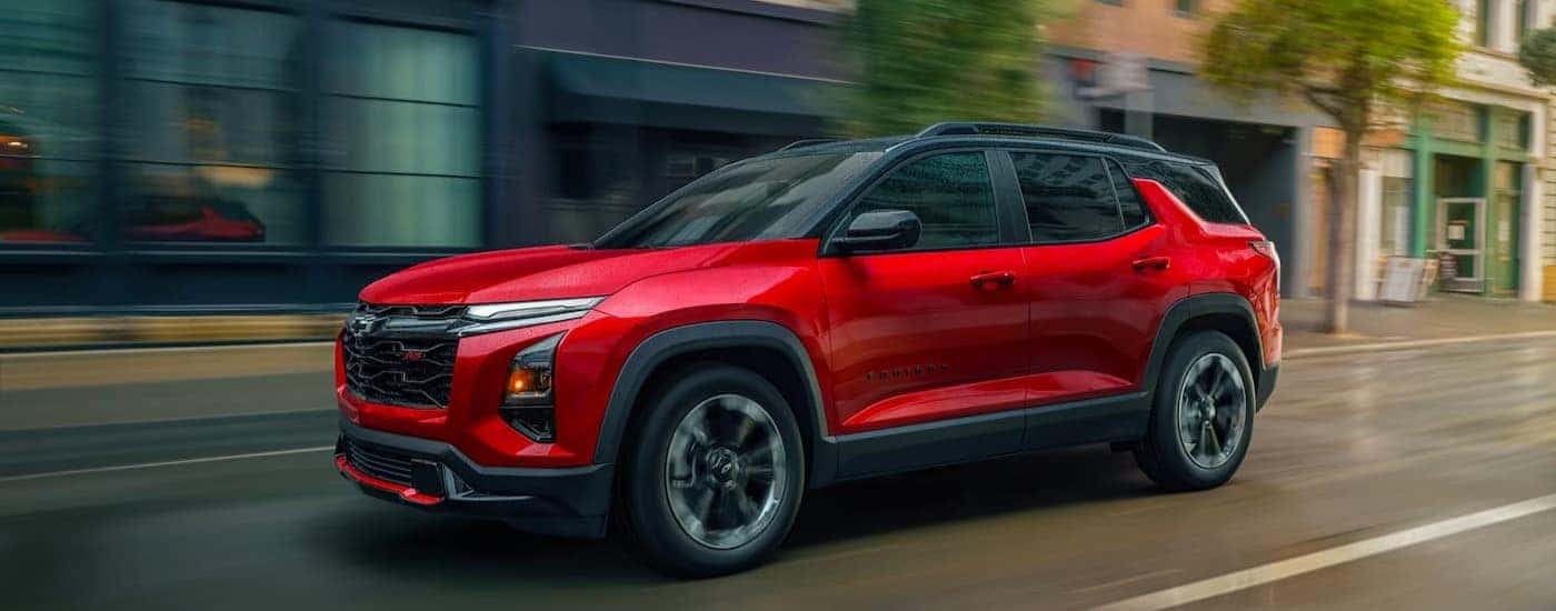 A red 2026 Chevy Equinox RS driving to visit a used Chevy dealer near Roebuck.