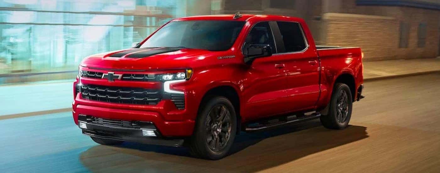 A red 2023 Chevy Silverado 1500 RST driving to visit a used Chevy dealer near Duncan.