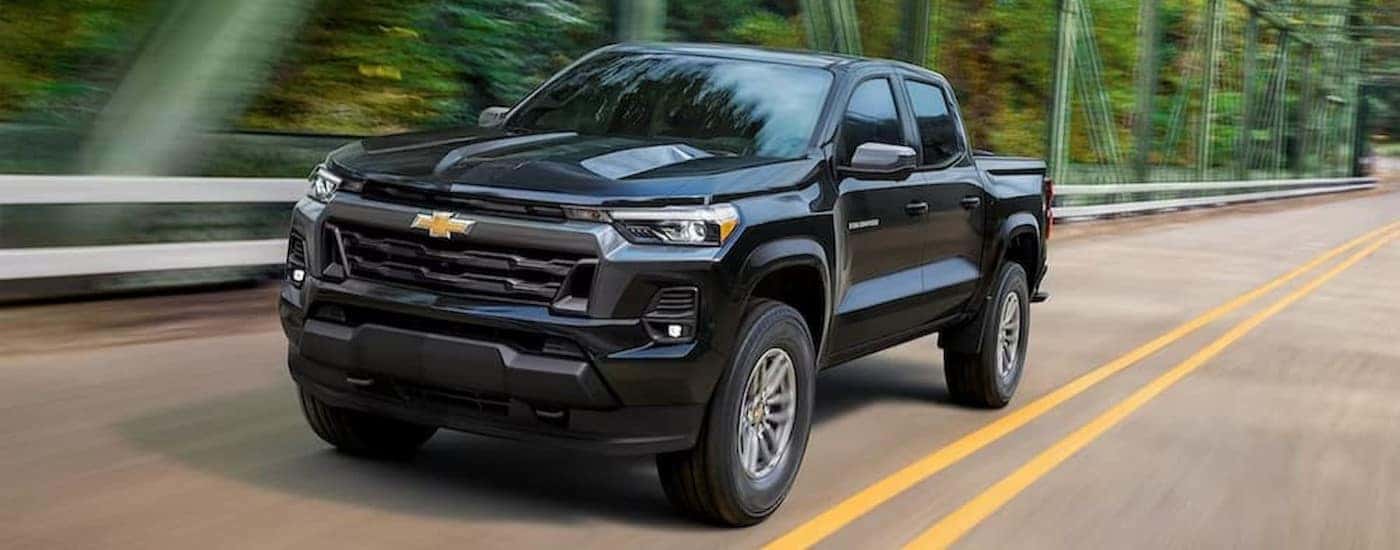 A black 2023 Chevy Colorado driving to a used Chevy dealer in Spartanburg.
