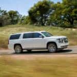 A white 2019 Chevy Suburban driving to a used car dealer.