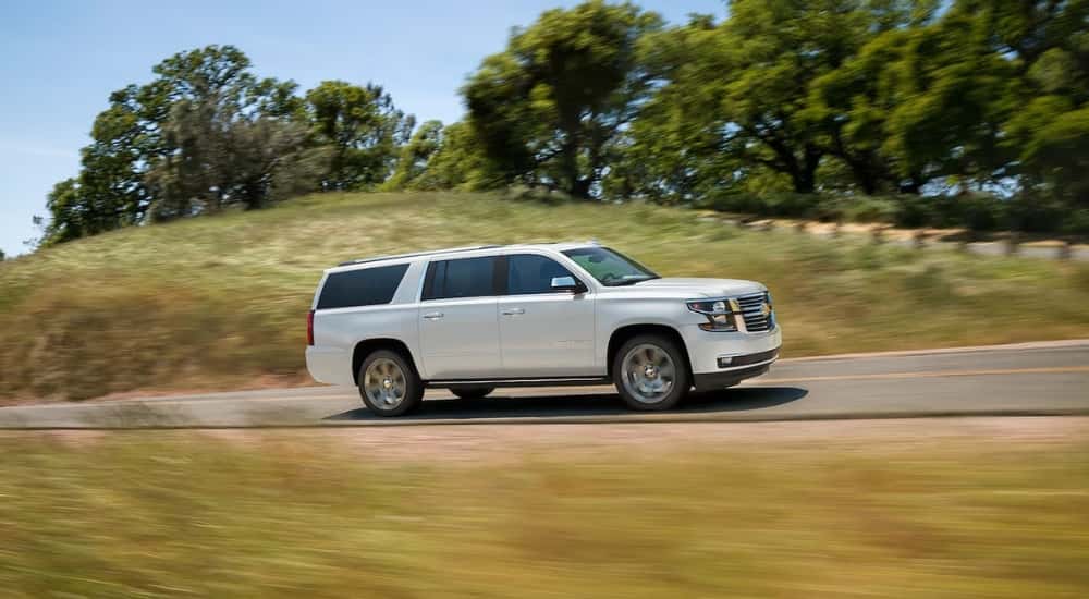 A white 2019 Chevy Suburban driving to a used car dealer.