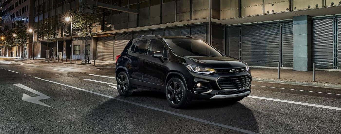 Black 2018 Chevy Trax driving through a city.