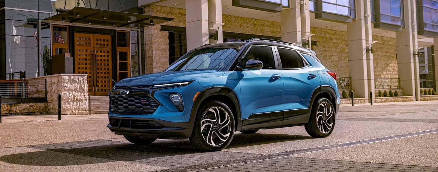Blue 2025 Chevy Trailblazer RS driving down a road.