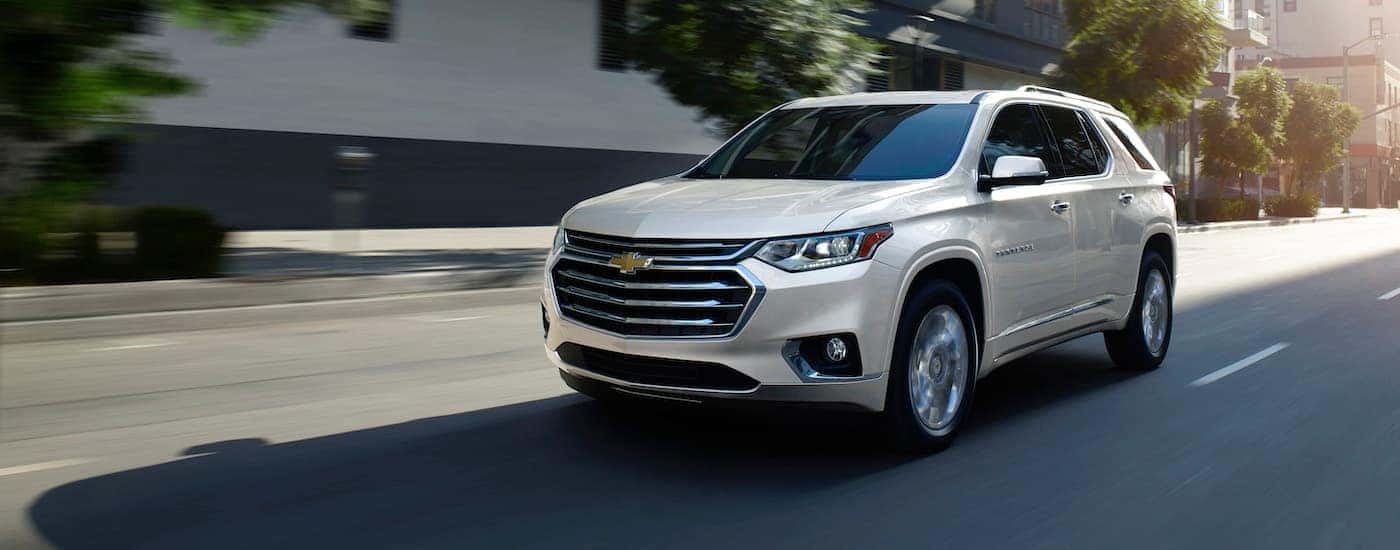 White 2019 Chevy Traverse driving on a city street to a used car dealer in Spartanburg