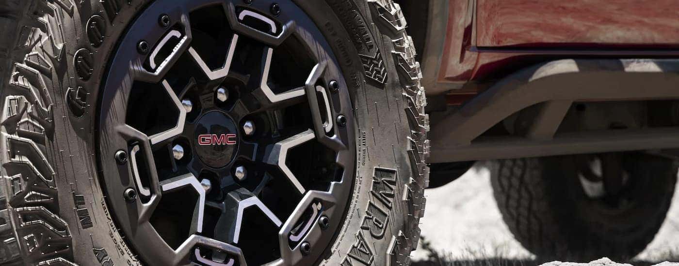 Close up of the dusty wheel on a red 2023 GMC Canyon AT4X