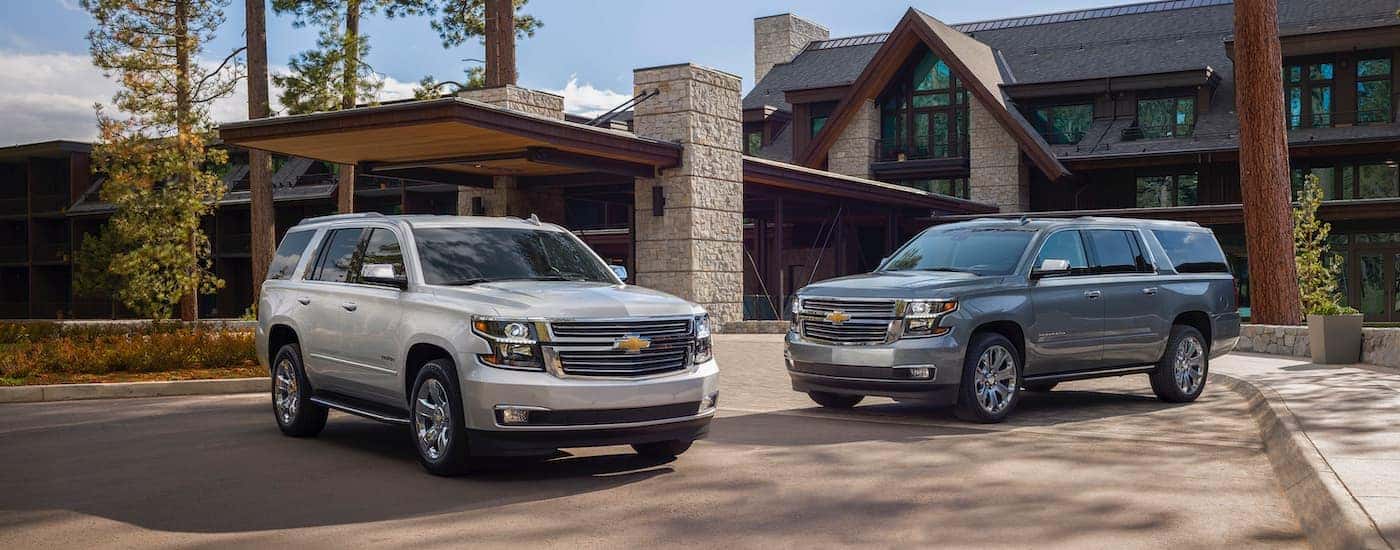 Two 2020 Chevy Suburbans parked in front of a home getting ready to look at a used chevy for sale