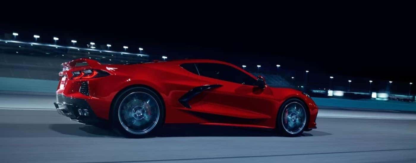 A red used 2024 Chevy Corvette Stingray for sale in Spartanburg driving down a road.