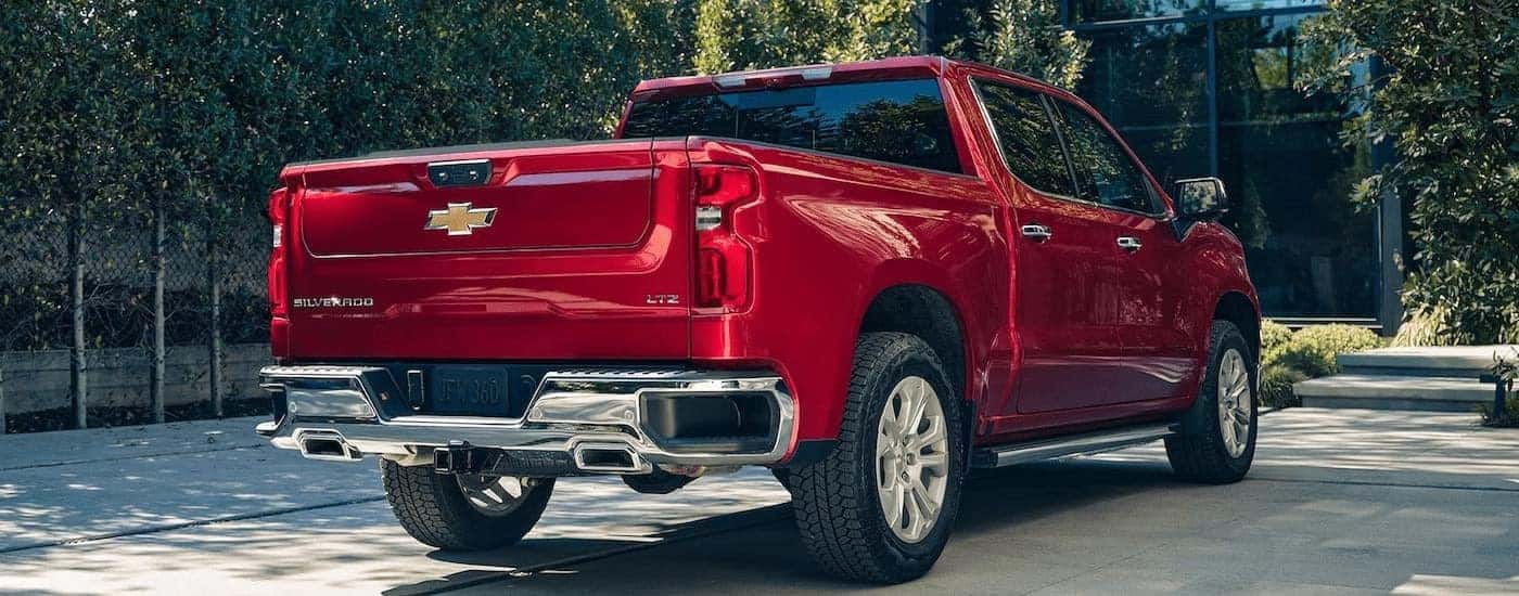 Red 2023 Chevy Silverado 1500 driving to see trucks for sale