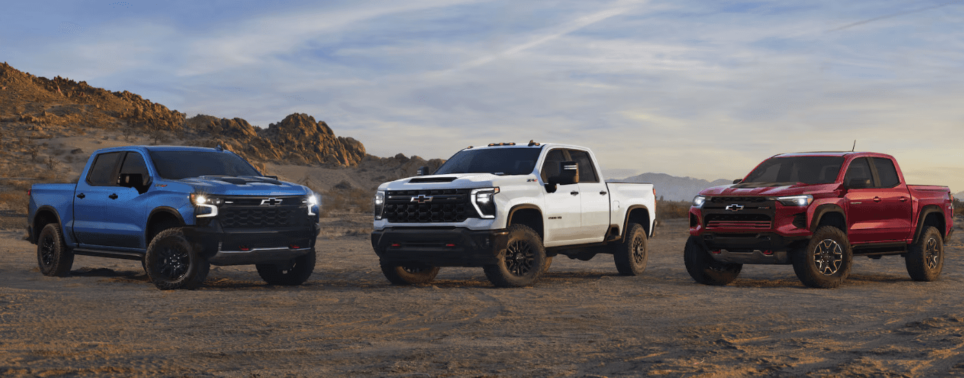 Blue 2026 Chevy Silverado 1500 ZR2 next to a white 2026 Chevy Silverado 2500 HD ZR2 next to a red 2026 Chevy Colorado ZR2