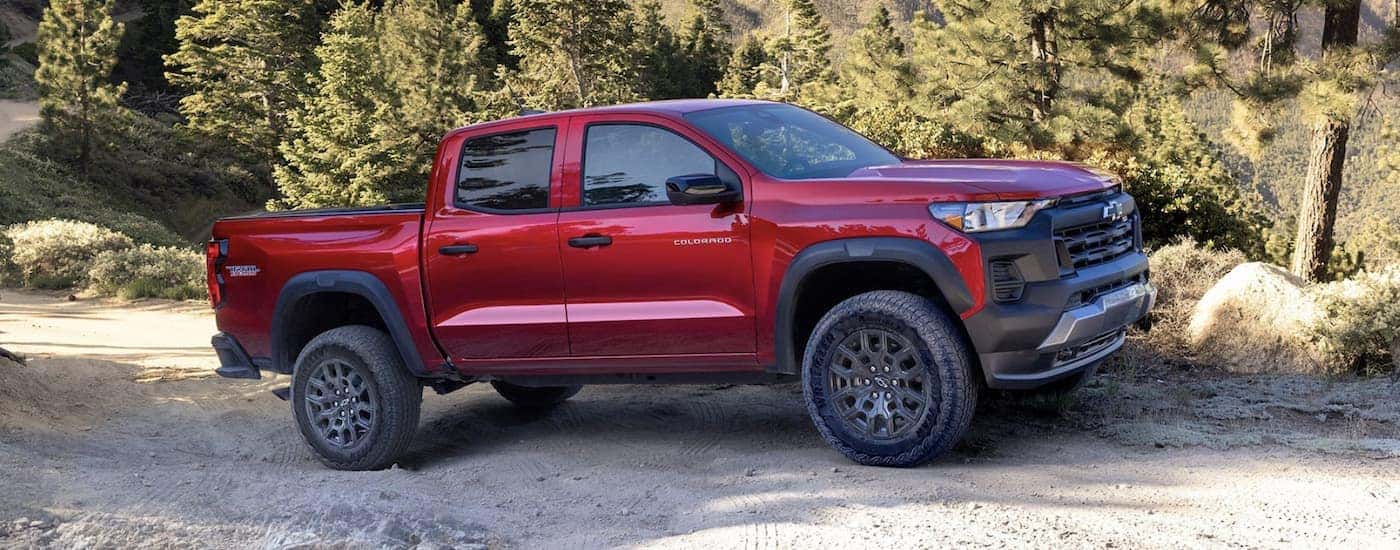 Side of a red 2025 Chevy Colorado driving off-road.
