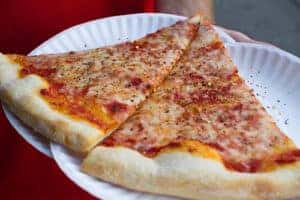 slices of cheese pizza on paper plate
