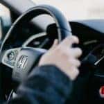 hands holding onto a honda steering wheel