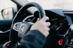 hands holding onto a honda steering wheel
