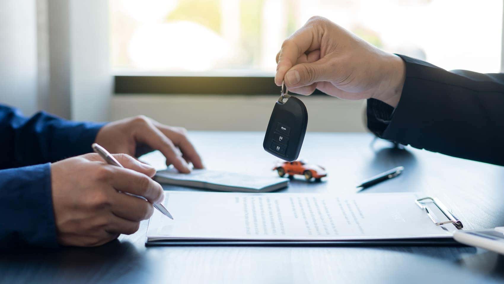Signing car lease agreement person handing over key