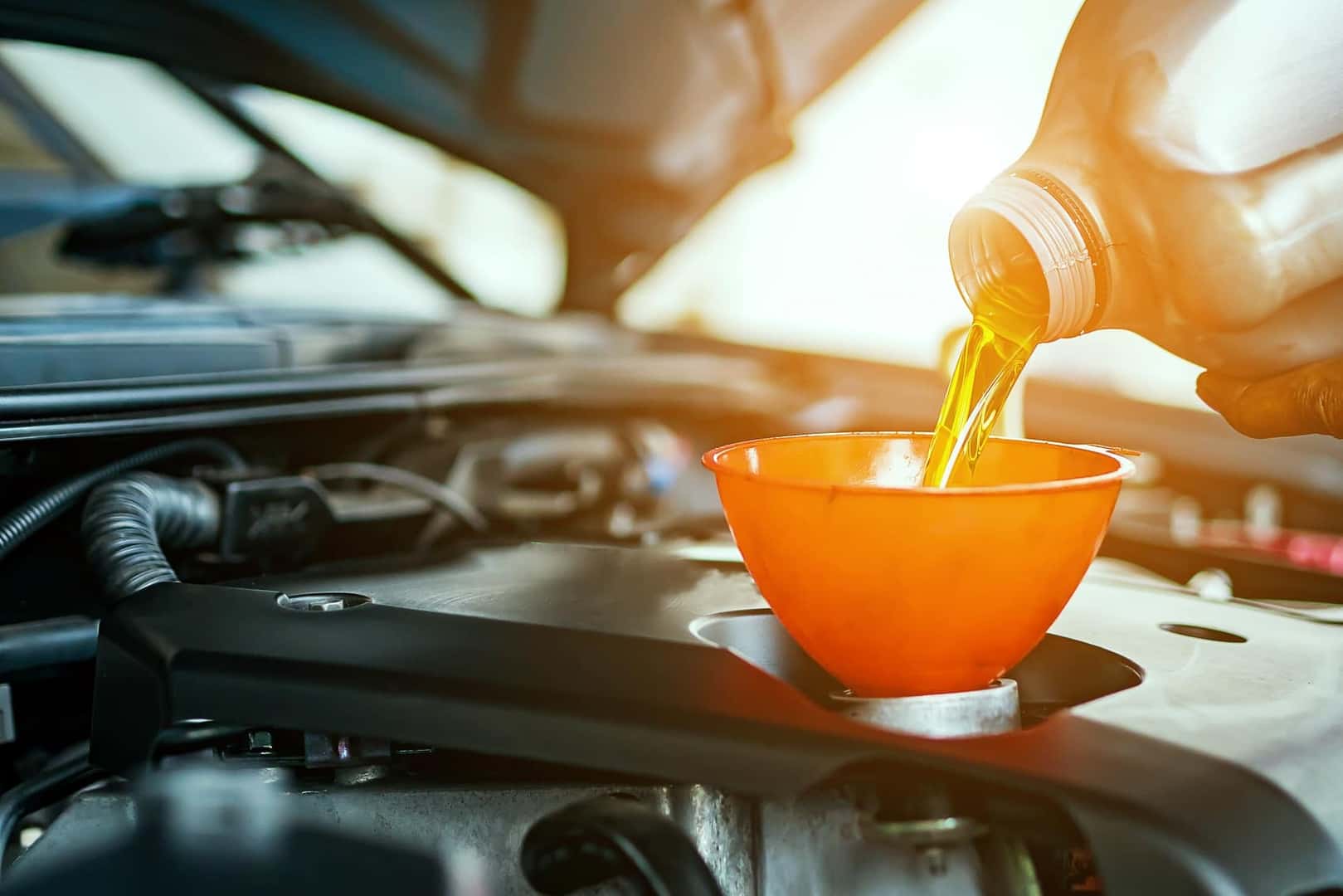 Technician changing car oil