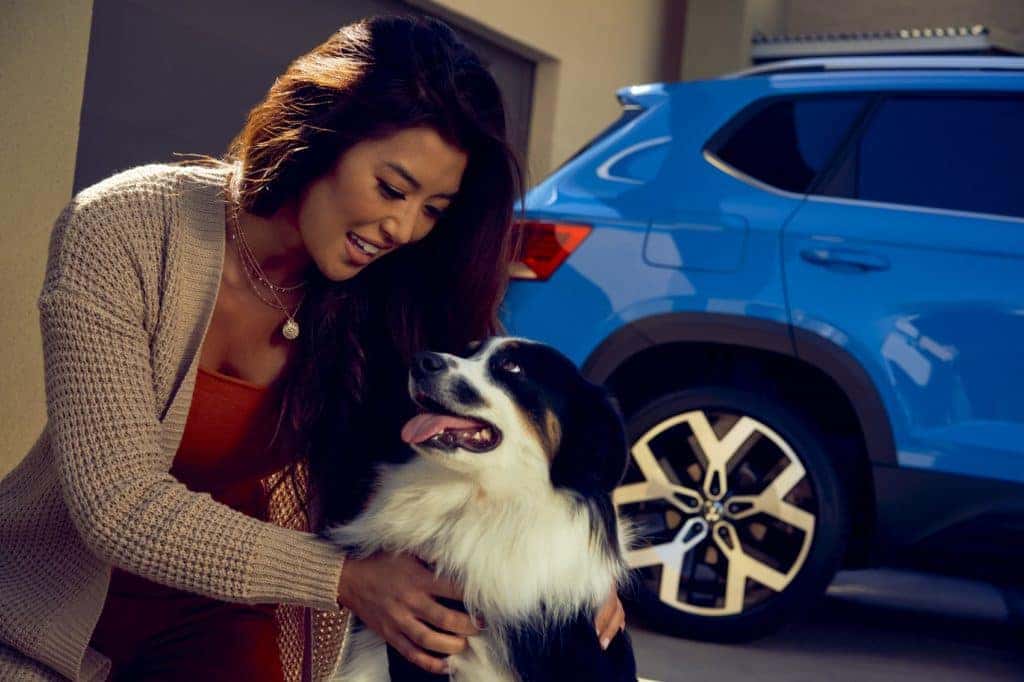 Womens Holding Dog Next to VW Taos