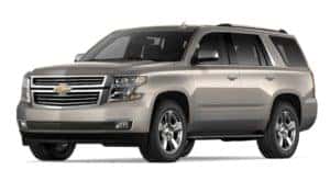 A tan 2019 Chevy Tahoe is facing left.