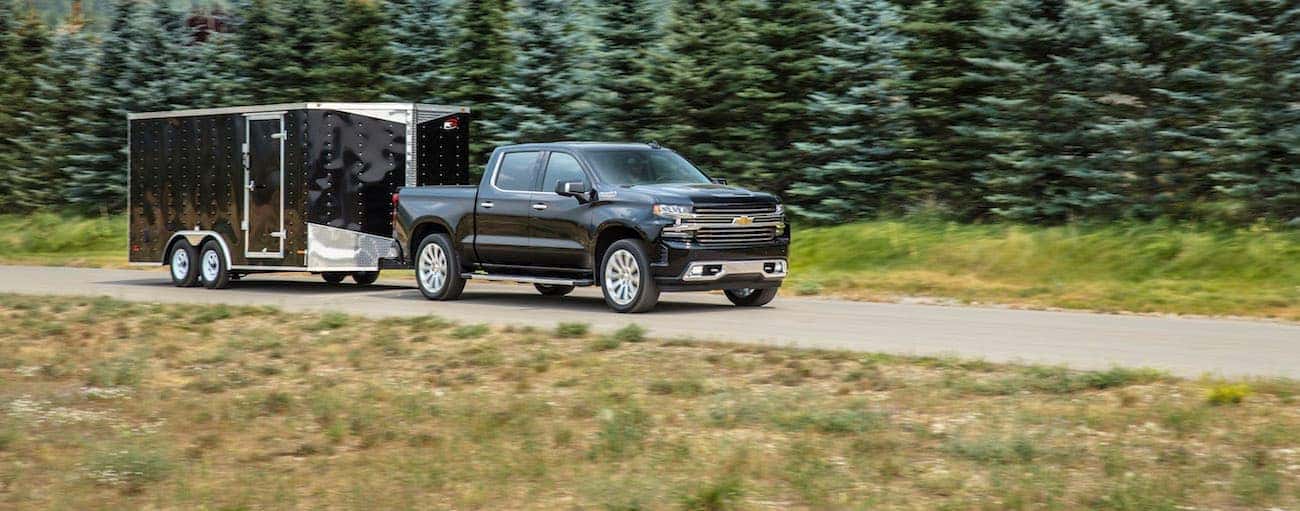A black 2019 Chevy Silverado, which wins when comparing the 2019 Chevy Silverado vs 2019 Ram 1500, is towing a trailer outside of Bethlehem, PA.