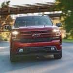 The front end of a red 2020 Chevy Silverado 1500 is shown while driving on a treelined road near Bethlehem, PA.