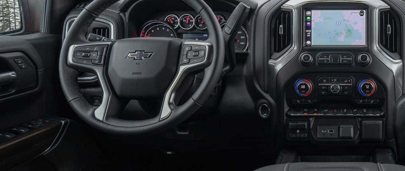A close up of the driver's black leather interior is shown with an infotainment system. 