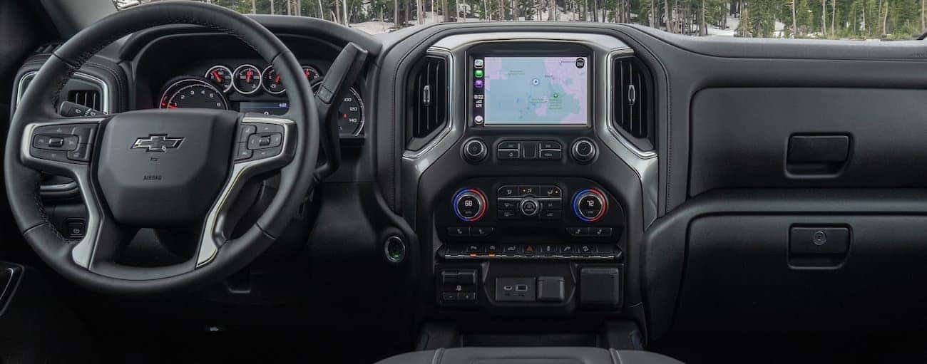 The front grey interior of a 2020 Silverado 1500 is shown with an infotainment system is shown.