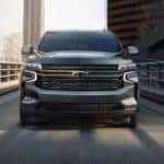 A grey 2021 Chevy Tahoe is shown from the front on a city highway.