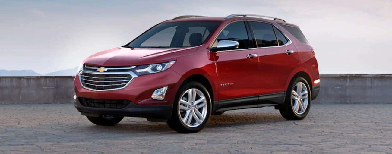A red 2020 Chevy Equinox is parked in front of a low grey wall near Bethlehem, PA.