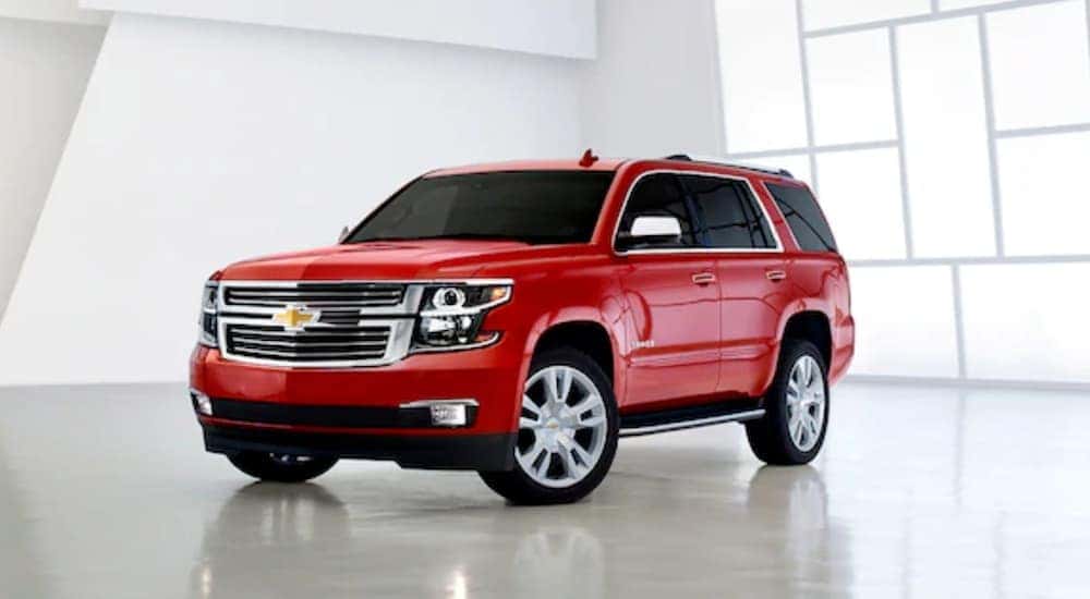 A red 2020 Chevy Tahoe is parked in a white showroom at a Chevy dealer in Bethlehem, PA.