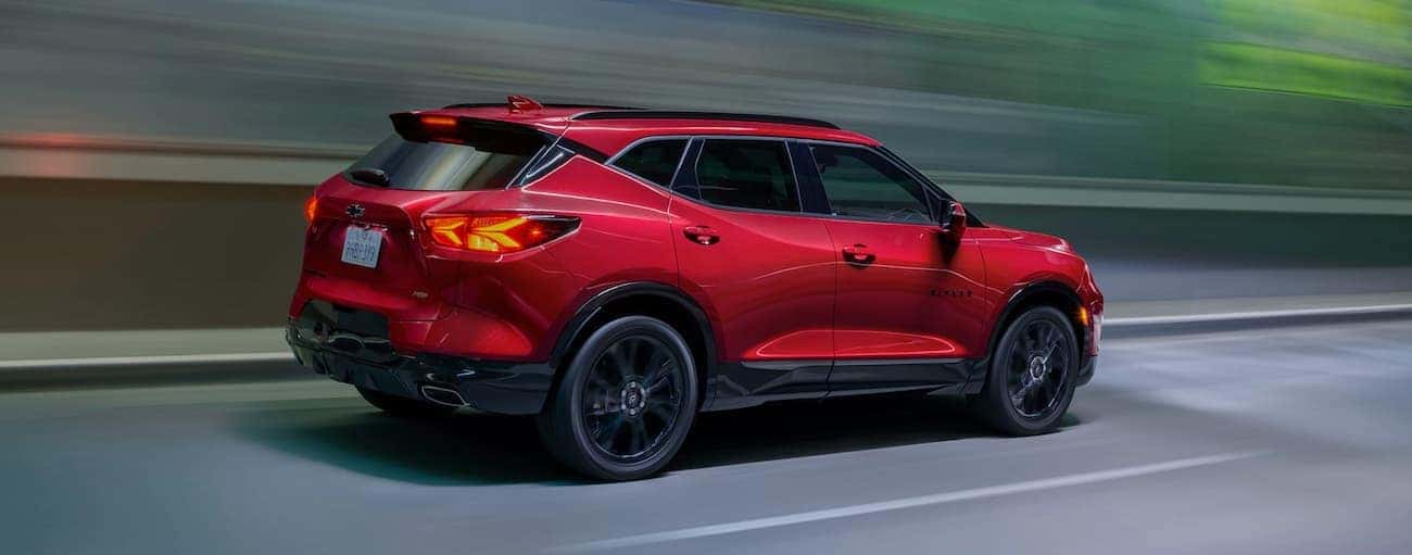 A red 2021 Chevy Blazer RS is driving out of a very blurred tunnel.