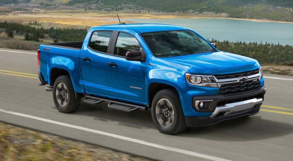 A blue 2021 Chevy Colorado is driving past a lake after leaving a Chevy dealer in Nazareth, PA.
