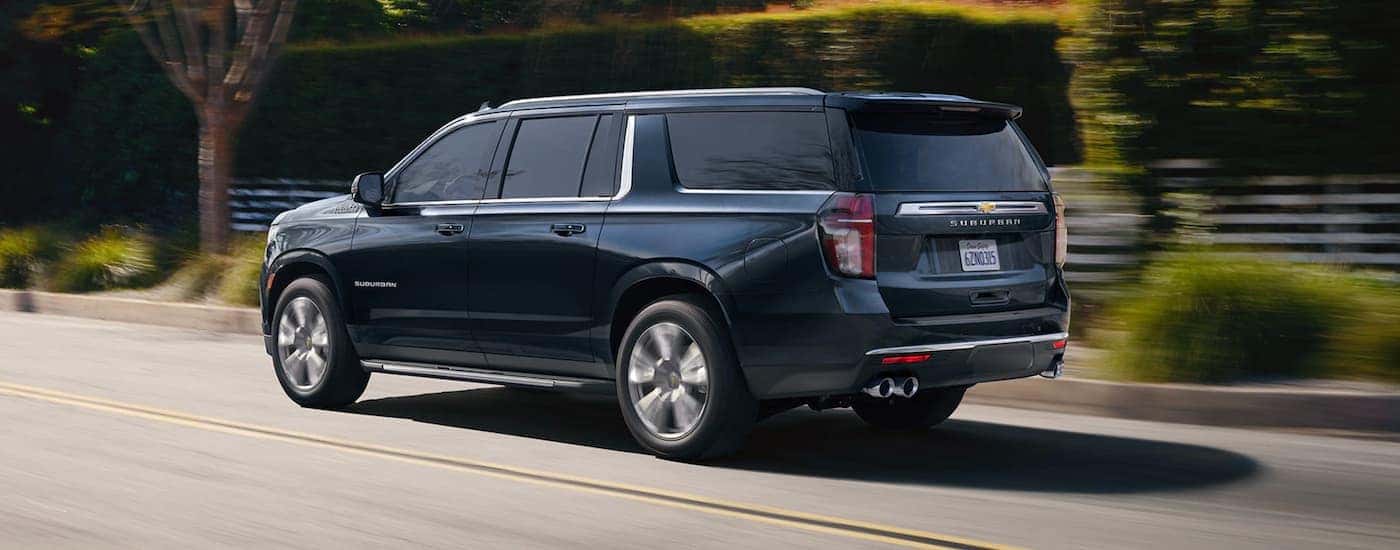 A blue 2021 Chevy Suburban is driving on a suburban street after leaving a Chevy dealer in Allentown, PA.